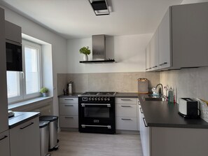 Een microgolfoven, een oven, een kookplaat, een vaatwasser