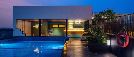 Un edificio moderno con piscina y zona de bar.