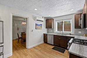 A modern kitchen with wooden cabinets, a stainless steel refrigerator, and a built-in oven.