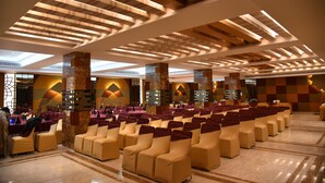 A spacious hall with rows of seating, high ceilings with wooden beams, and large windows allowing natural light. - The Narayanam Hotel (Gwalior)