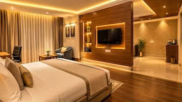 A modern hotel room with a large bed, a flat-screen TV mounted on the wall, and a wooden accent wall.