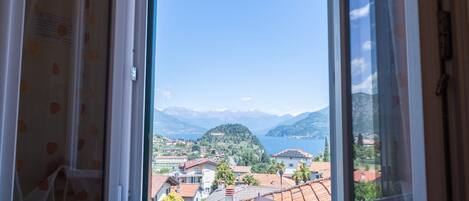 A window with a view of a mountainous landscape and a lake.