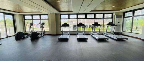 A gym with treadmills, elliptical machines, and weight benches.