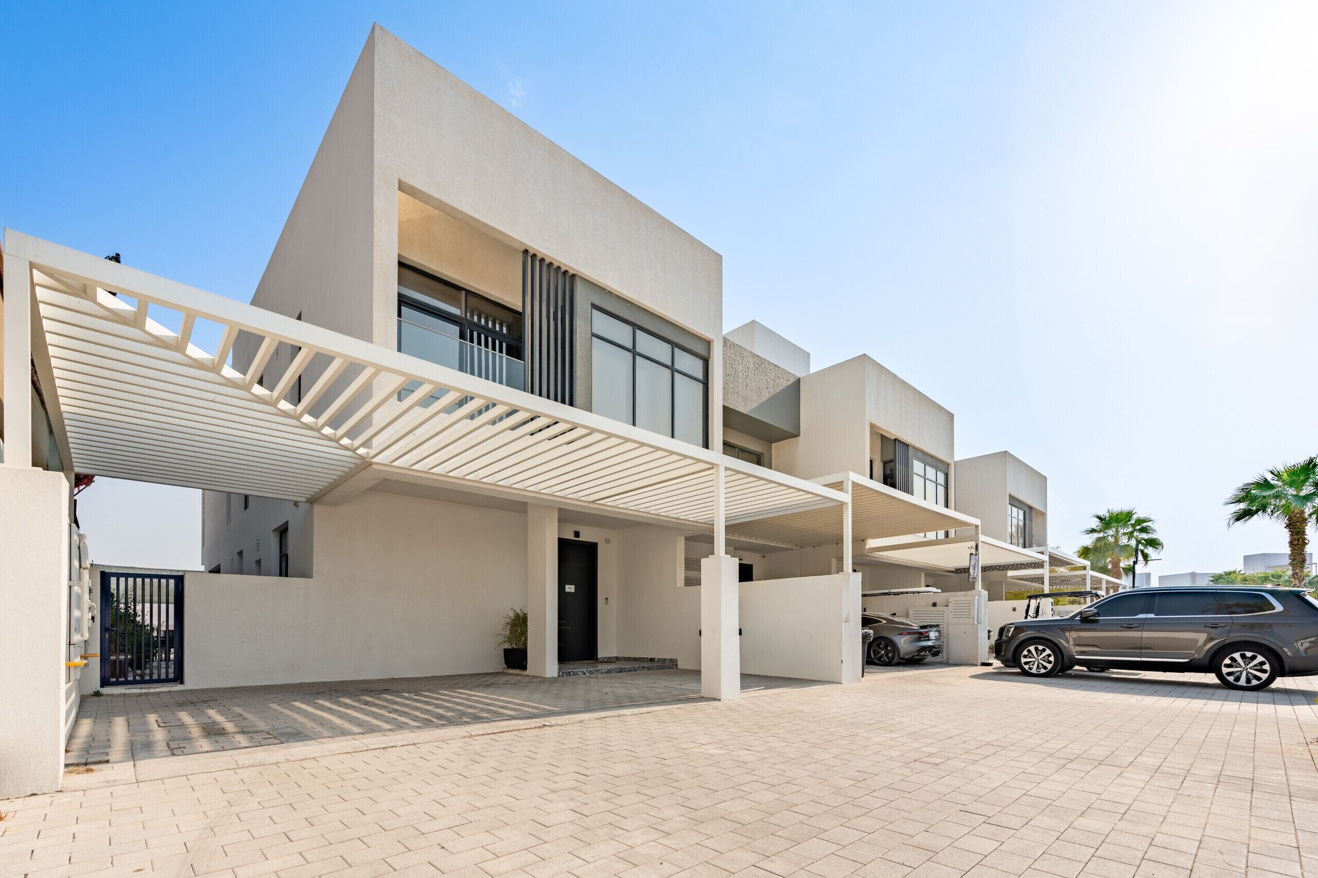 Un immeuble moderne à plusieurs étages, doté d’un parking couvert et où une voiture est stationnée à l’intérieur.
