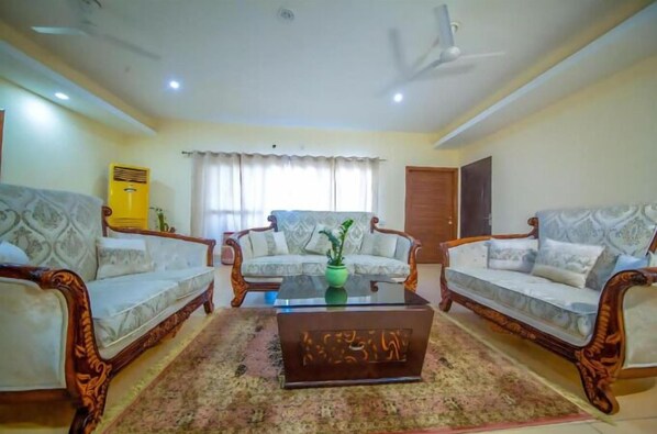 A living room with two sofas, a coffee table, and a ceiling fan.