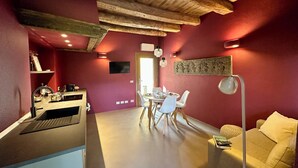 Una cocina moderna con comedor, que presenta un techo de madera, una pared roja y una mesa de comedor con sillas.