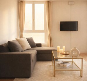 Apartamento família, vista para a cidade | Área de estar | Smart TV 80 cm com canais digitais