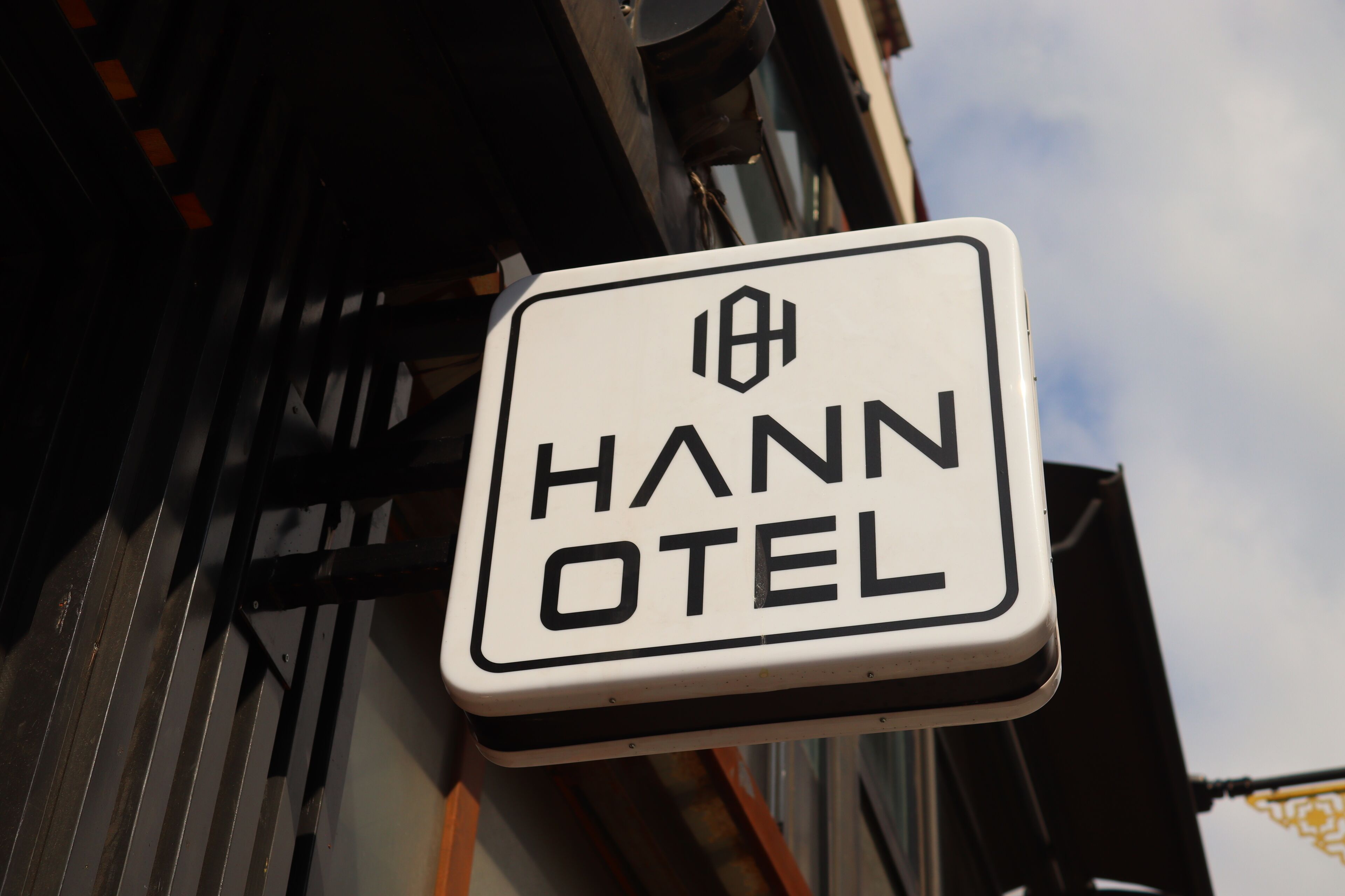Une enseigne indiquant « HANN OTEL », avec une police de caractères simple et claire sur un fond blanc.