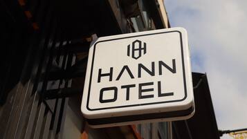 Une enseigne indiquant « HANN OTEL », avec une police de caractères simple et claire sur un fond blanc.