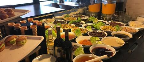 A buffet with various food items and condiments.