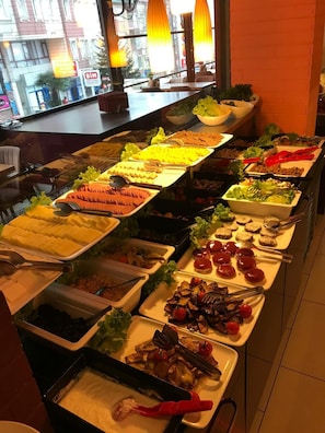 A buffet with various food options, including fruits, vegetables, and meats.