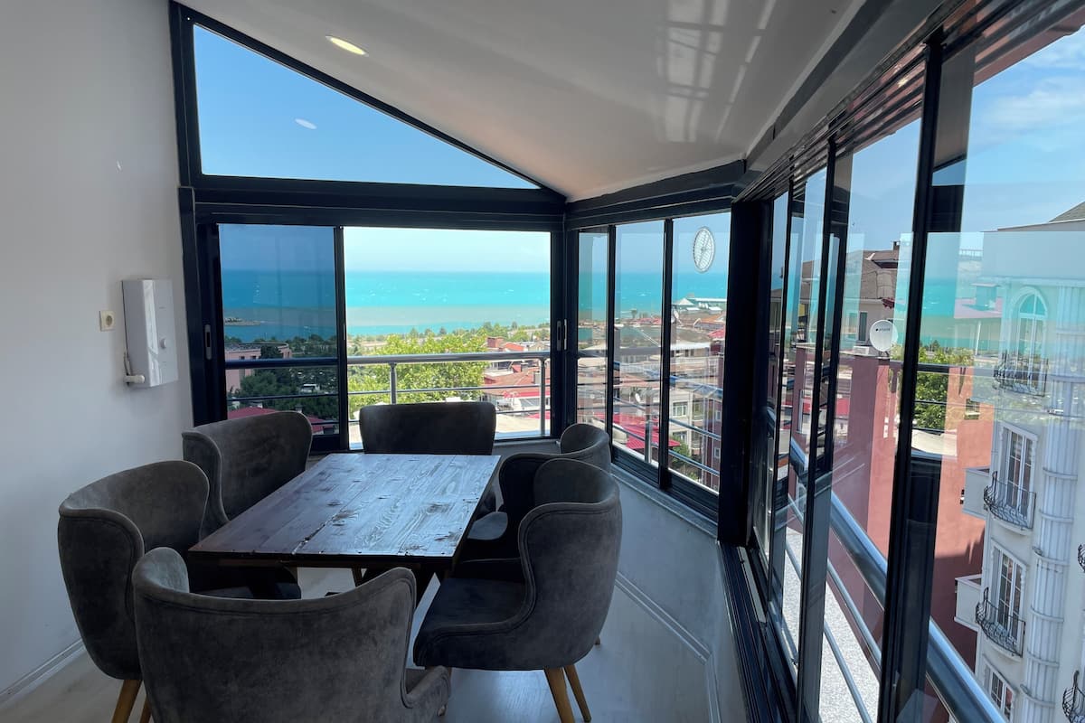 A balcony with a view of the sea and buildings.