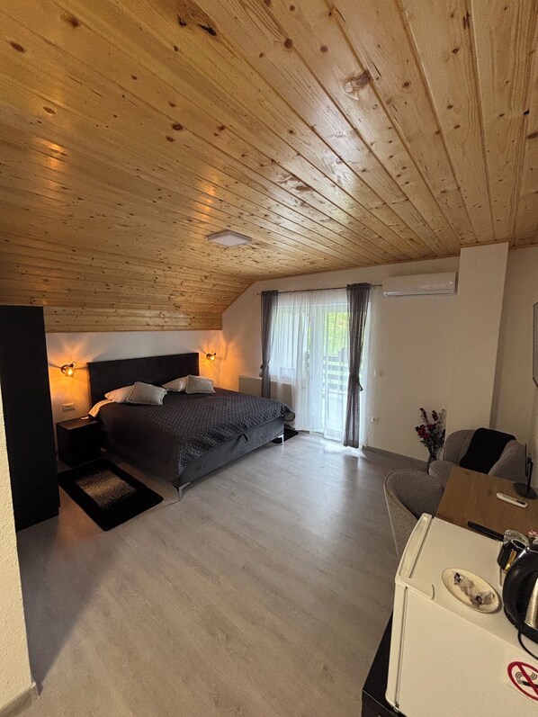 A bedroom with a wooden ceiling, a bed, a desk, and a chair. - Estate Pavlić (Rakovica)