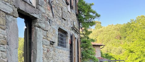 A stone building with large windows and a balcony.