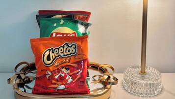 A tray with three bags of Cheetos snacks and a lamp on a table.