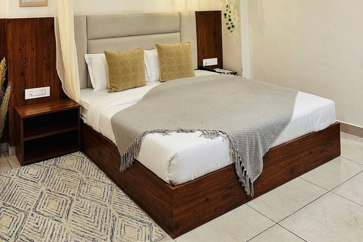 A modern bedroom with a large bed, a ceiling fan, and a decorative canopy.
