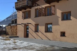 A building with a balcony, multiple windows, and a door.