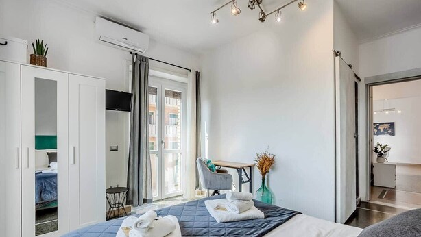 Une chambre d’hôtel moderne équipée d’un lit, d’un bureau, d’une chaise et d’une armoire.