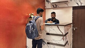 Un comptoir d’accueil au design en marbre, un mur rouge et un sol à motifs.