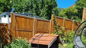 A wooden structure with a roof, a small pond with lily pads, and a fence in a garden setting. - Apartment "Olympe" – Terrace and Garden, Ideal for Couples or Small Families (Périgueux)