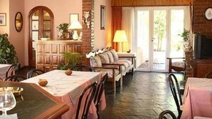 A dining area with a brick wall, wooden furniture, and a view through a glass door.