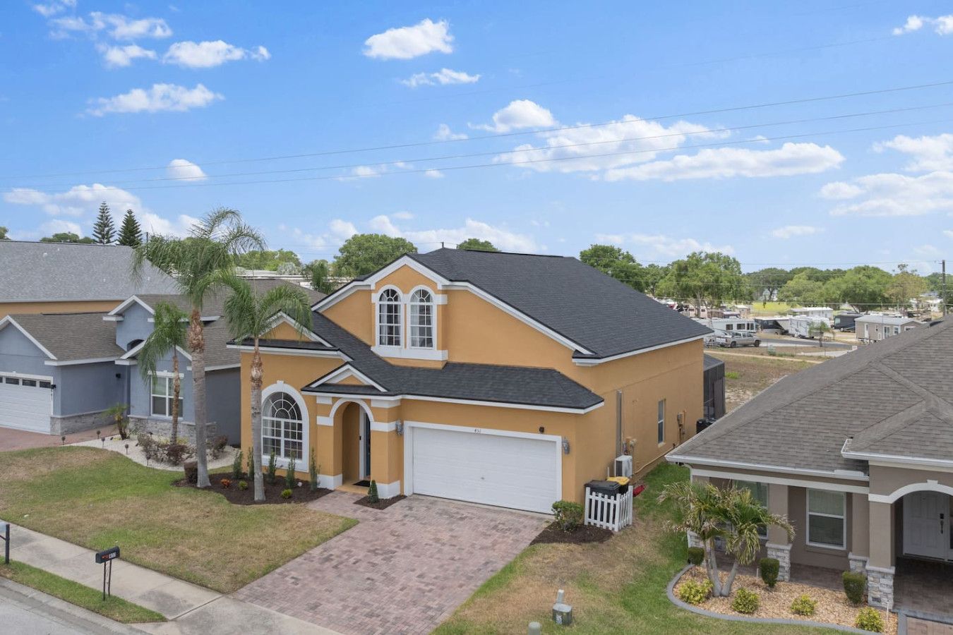 A residential house with a garage, a driveway, and a well-maintained lawn.