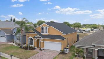 A residential house with a garage, a driveway, and a well-maintained lawn.