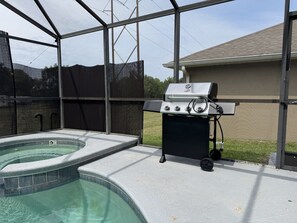 Ein Garten mit Whirlpool und Grill.