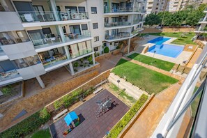 A multi-story residential building with balconies, a swimming pool, and a children's play area. - Apartment 'Cala Alta' with Sea Views, Wi-Fi and Air Conditioning (Benidorm)