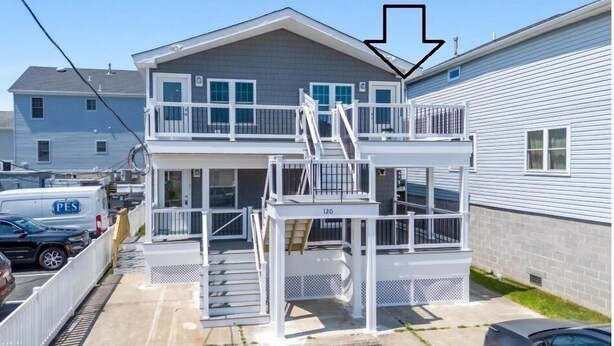 A two-story house with a balcony and a staircase leading to the second floor.