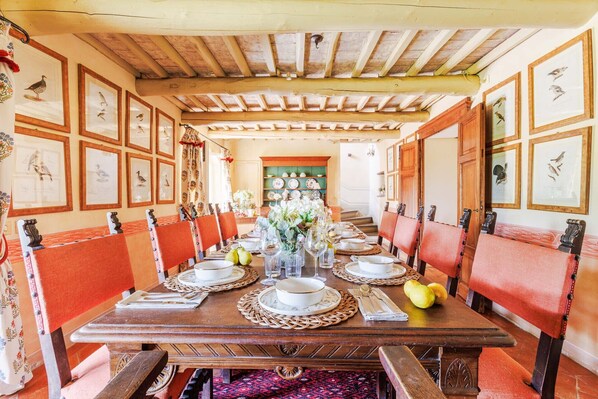 A long dining table with red upholstered chairs, framed bird pictures on the walls, and a wooden ceiling. - Iconic Romantic Farmhouse with Pool in Lucca (Lucca)
