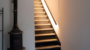 A staircase with a modern light fixture and a vintage stove. - 'Patata Gialla' Room with Mountain View, Wi-Fi and Air Conditioning (Bormida)