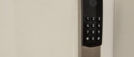 A modern door with a numeric keypad and a sleek handle.