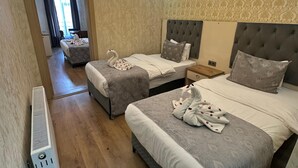 Ein Hotelzimmer mit zwei Betten, einem Heizkörper und Blick auf die Stadt.