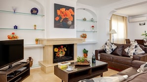 Una sala de estar moderna con chimenea, televisor y sofá.
