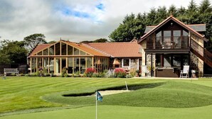 A golf course with a clubhouse featuring a large deck and a stone facade. - St Andrews Retreat - Ten Bedroom Villa, Sleeps 20 (Cupar)