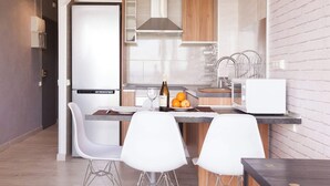 A modern kitchen with a built-in microwave, a wine bottle, and fresh fruit on the counter.