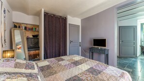 Une chambre à coucher avec un lit, une télévision, un miroir et une bibliothèque.