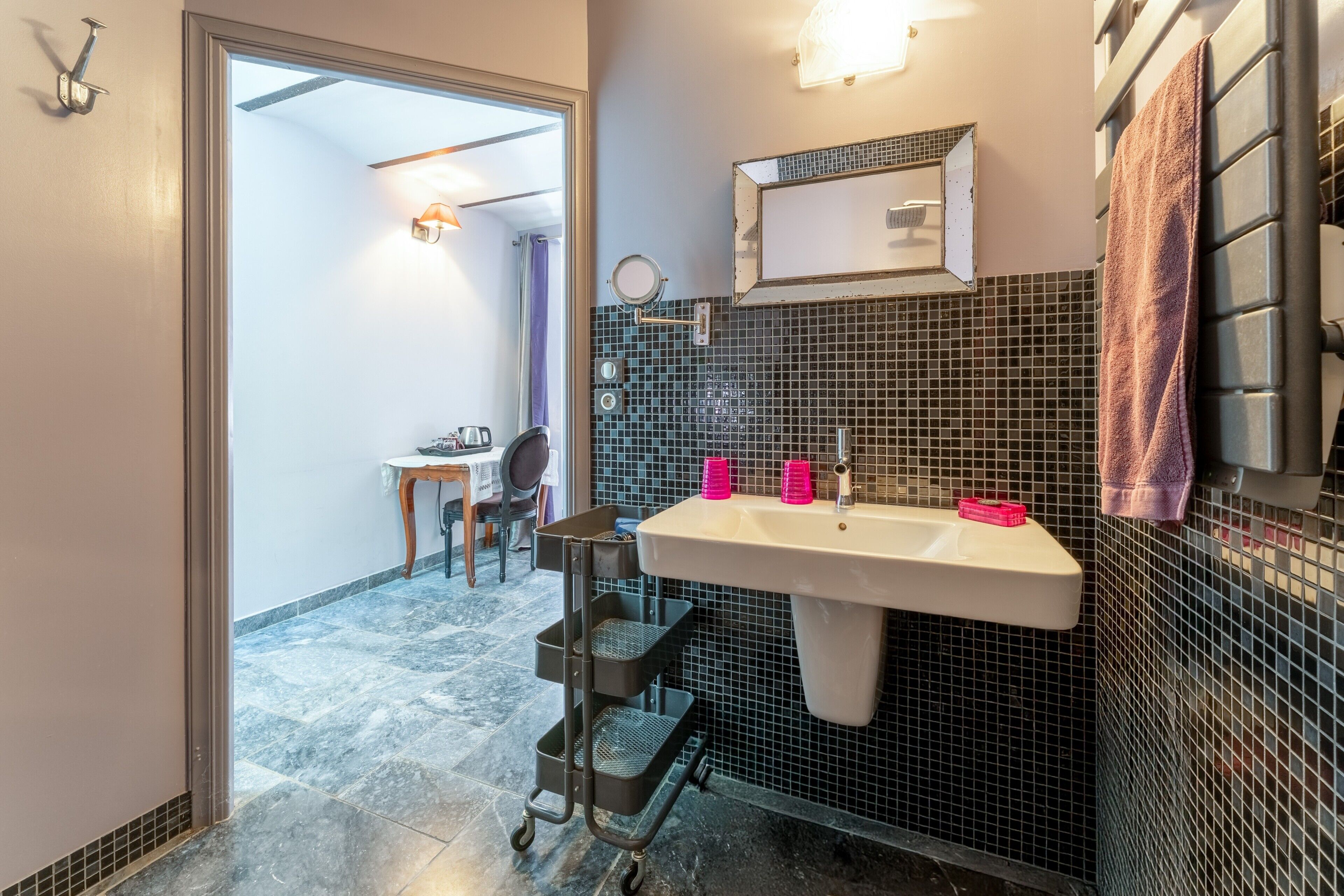 Une salle de bain équipée d’un lavabo, d’un miroir et d’un porte-serviettes.