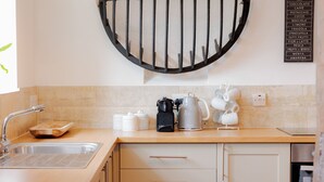 A modern kitchen with a sink, countertop, and storage cabinets. - Stable Cottage (Bridgnorth)