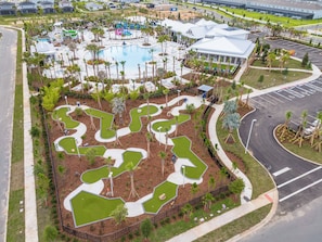 Vista aérea de un resort con piscina, zonas ajardinadas y aparcamiento.