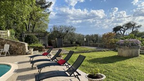 A poolside area with lounge chairs and a small garden. - Villa Reflets du Sud (LA GAUDE)