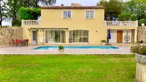 A two-story house with a swimming pool, a covered patio, and a stone wall. - Villa Reflets du Sud (LA GAUDE)