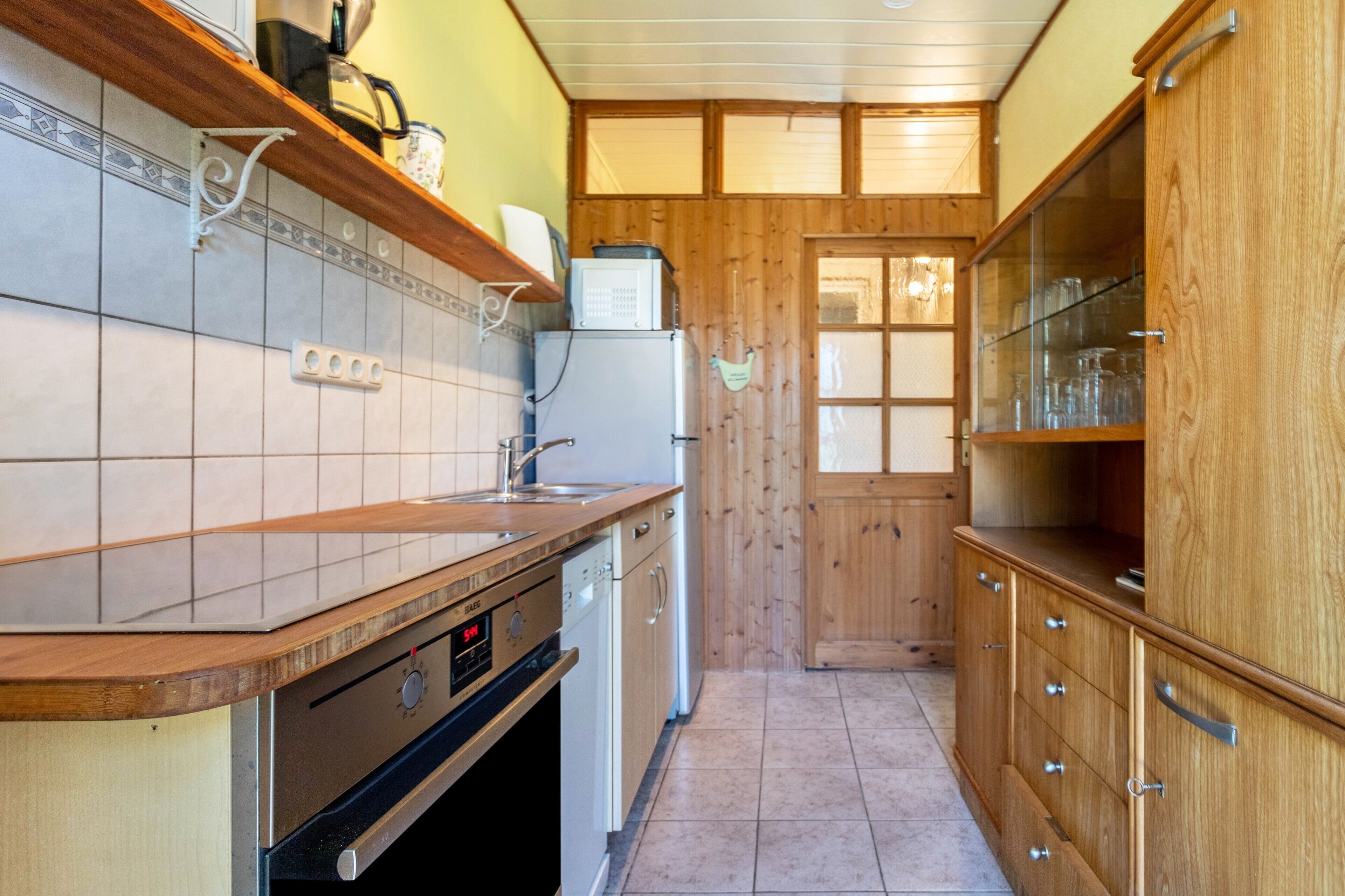 A kitchen with wooden cabinets, a dishwasher, and a refrigerator.