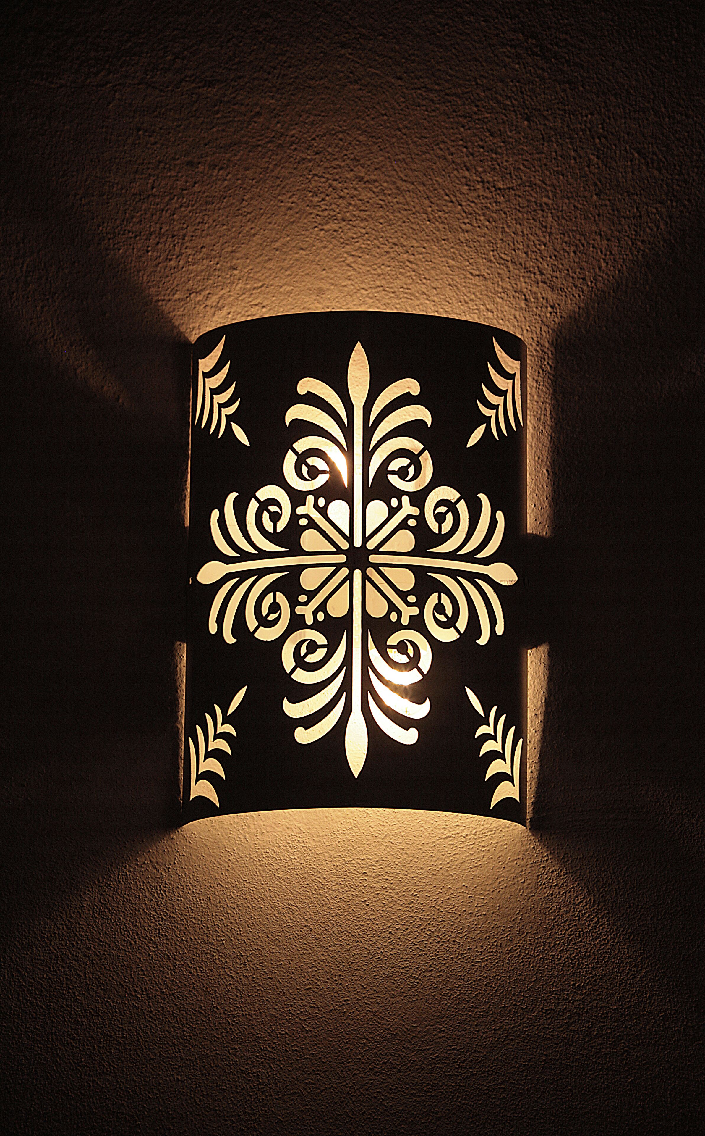Un luminaire mural orné d’un motif décoratif.