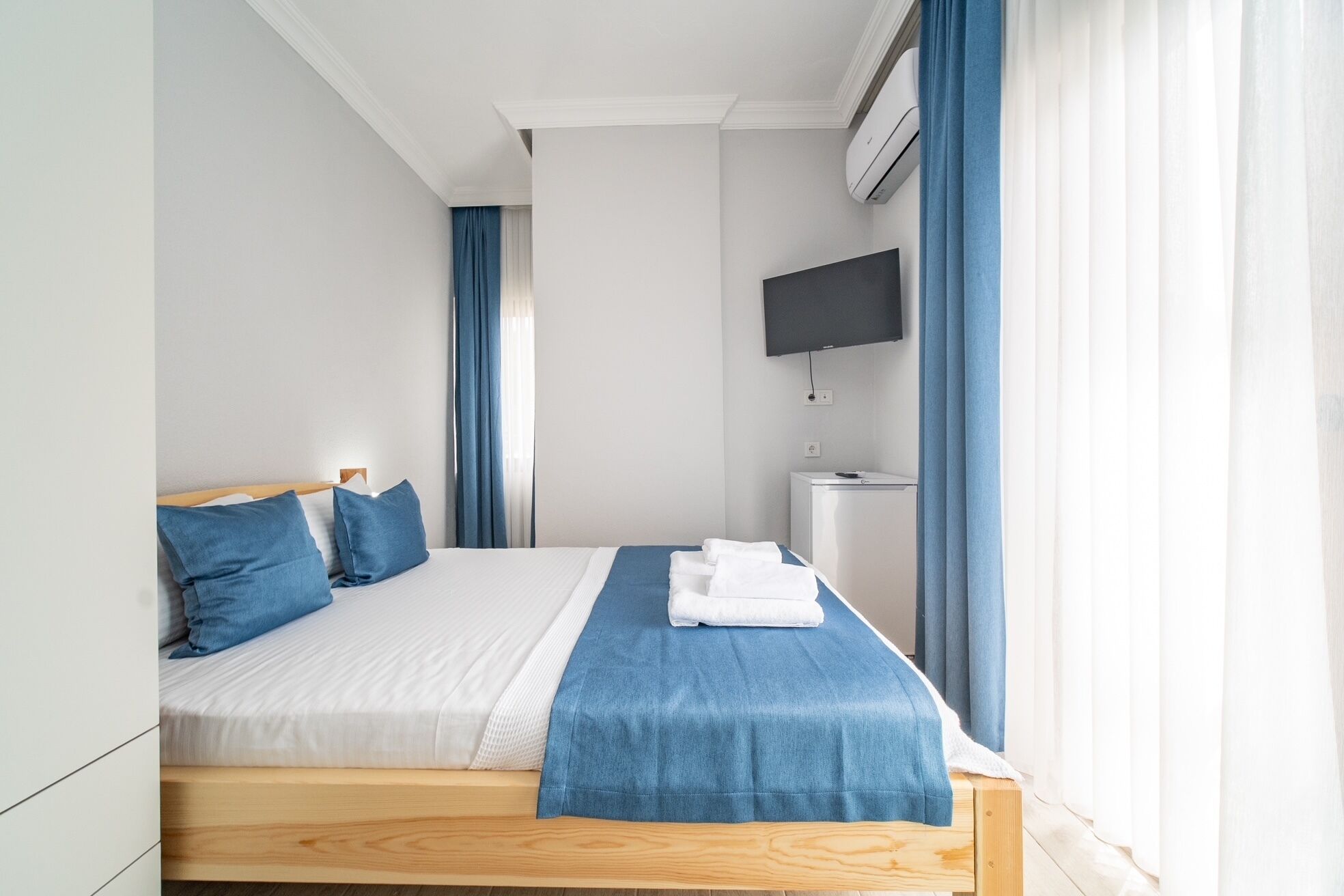 Une chambre d’hôtel avec un lit, une télévision et une petite table.