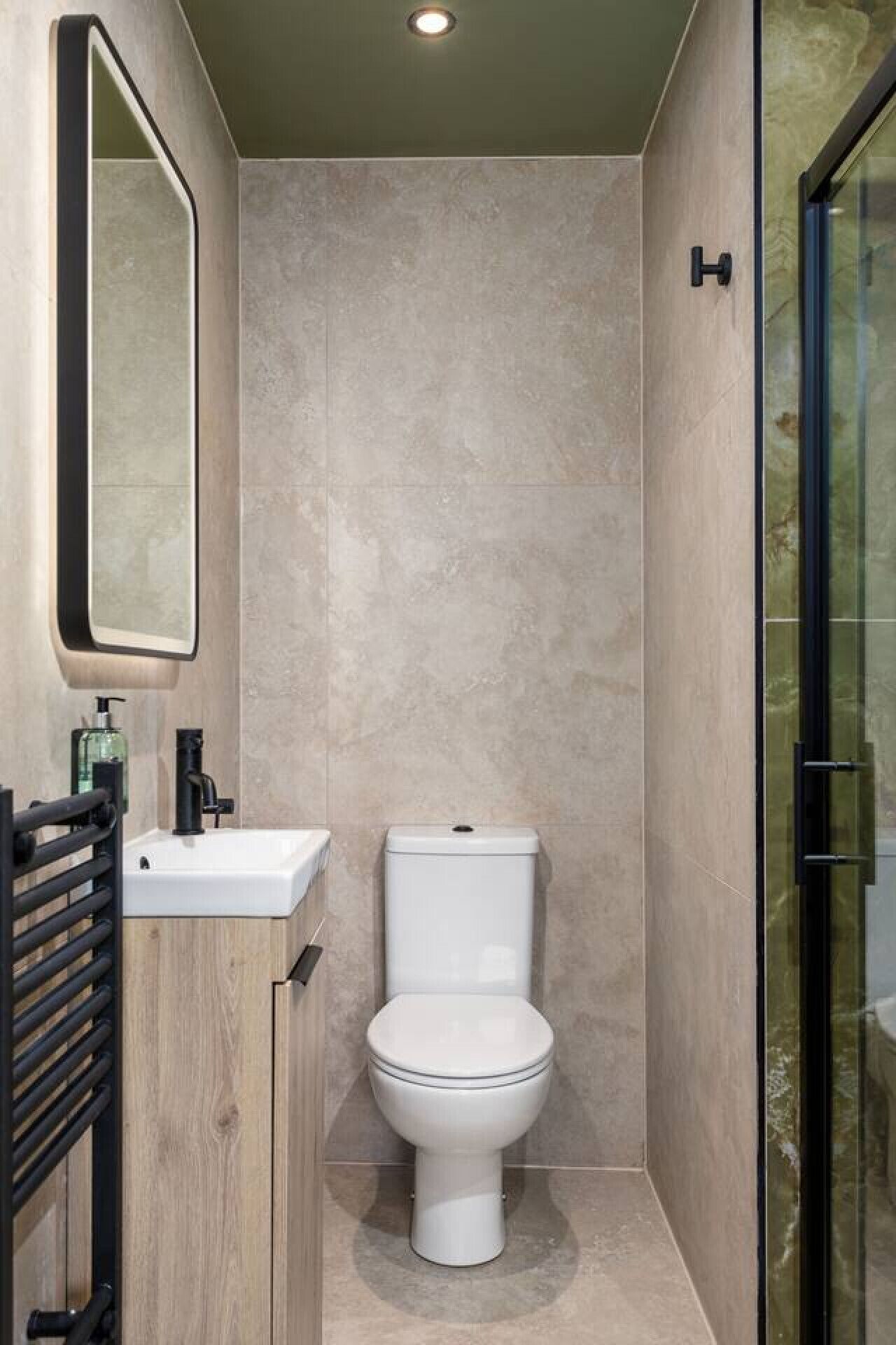 A modern bathroom with a toilet, sink, and mirror.