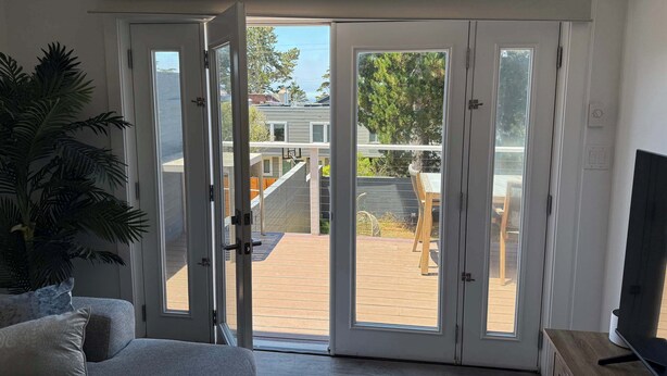 A room with a sliding glass door leading to an outdoor patio area. - Cozy 2-Bedroom Guesthouse with Private Patio (San Francisco)
