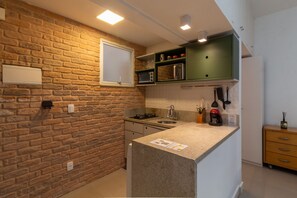 A kitchen with a stone backsplash, a built-in microwave, and a green upper cabinet. - 3 Minutes From Ipanema Beach Jn202 (Rio de Janeiro)