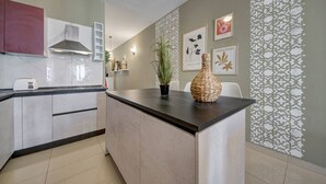 Una cocina moderna con una isla central, horno empotrado y salpicadero.